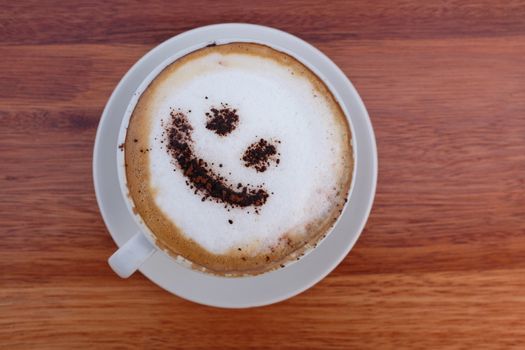 Coffee cappuccino with foam or chocolate smiling welcome happy face in restaurant or hotel