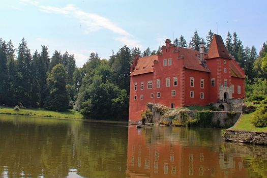 Photo shows red castle house and its surroundings.