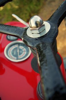 close-up on a red tractor with black steering wheel and panel with gauges