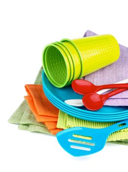 Stack of Multi Colored Cloth Napkins with Plastic Plates, Spoons and Cups isolated on White background