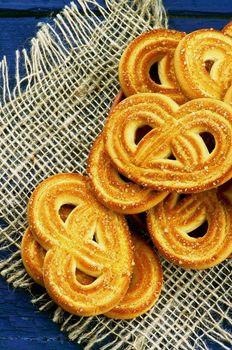 Arrangement of Homemade Shape Pretzel Sugar Cookies closeup on Sackcloth isolated on Dark Blue Wooden background. Top View