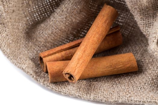 cinnamon sticks on hessian canvas with white background