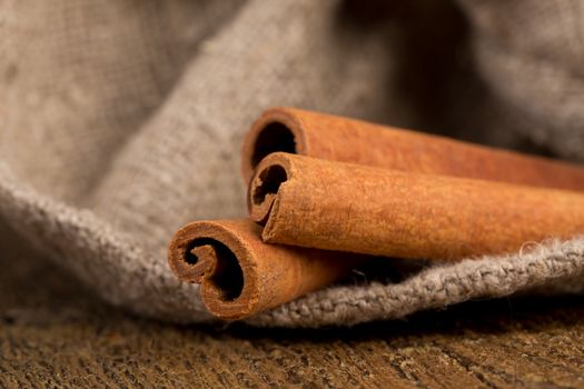 cinnamon sticks on hessian canvas with wooden background