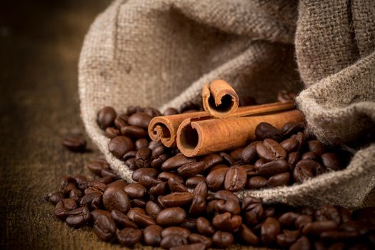 cinnamon sticks and coffee on hessian canvas with wooden background