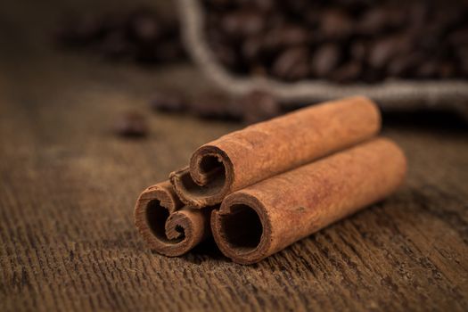 cinnamon sticks and coffee on hessian canvas with wooden background