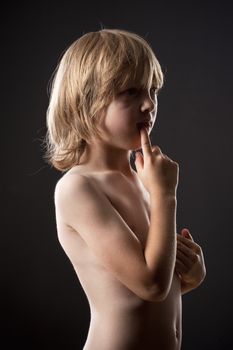 Portrait of a Boy with Blond Hair Thinking, Finger in his Mouth