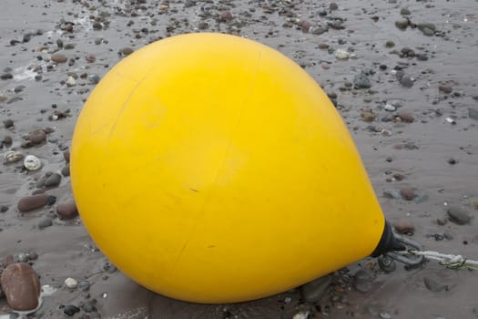 giant yellow buoy on a beach in the wild atlantic way