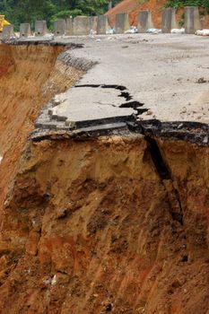 Side of the broken asphalt road collapsed and fallen, since the ground collapsing.