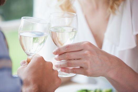 Young couple toasting with white wine at home in the dining room