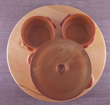 Crock pot and cups seen from above, over wooden table