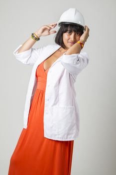 Young philipino engineer, wearing a sexy orange dress, hard hat and a lab coat