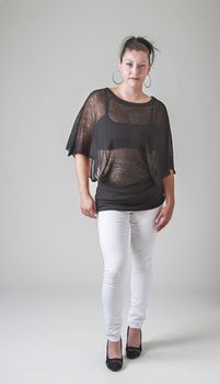 thirty something woman, wearing a transparent shirt, taking one step