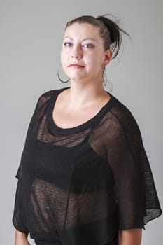 thirty something woman, wearing a transparent shirt looking up