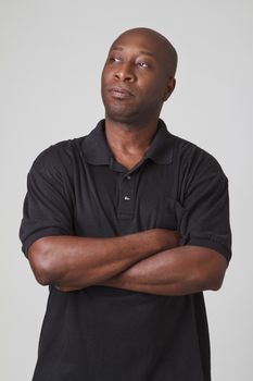 bald black man with his arm cross, with a thinking look