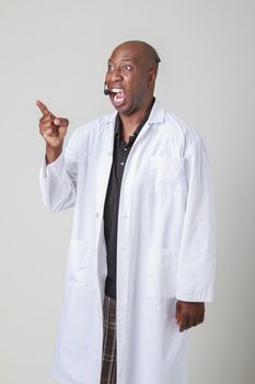 Forty year old black man, wearing a lab coat and a telephone headset, pointing and screaming at something