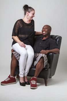 man, with a big smile, with his girlfriend sitting on his laps