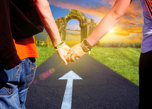 View of lovers couple holding hands on the road