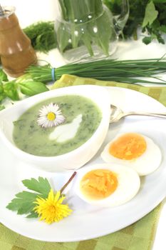 green herb soup with eggs and a dollop of cream