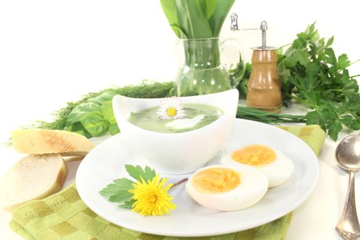 green herb soup with boiled eggs, a dollop of cream and daisy