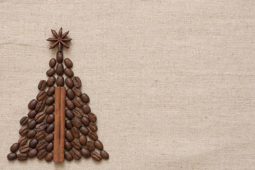 Christmas tree made of cinnamon sticks and coffee on linen background