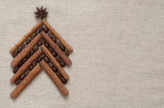 Christmas tree made of cinnamon sticks and coffee on linen background
