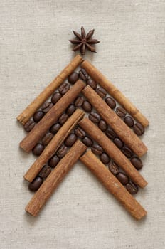 Christmas tree made of cinnamon sticks and coffee on linen background