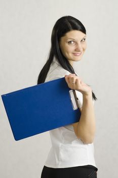 Business girl happily keeps the folder with the documents. The contents of the folder she pleased the client and the girl is very happy and cheerful. Studio, white background