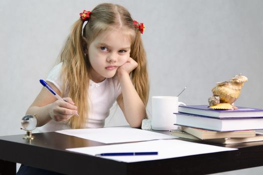 girl sits at a table and wrote on a sheet of paper. There are tombs of books, sheets of paper, a pen, glass globe, with a glass of tea, sea shell. The image of the writer
