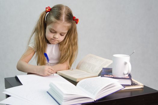 girl sits at a table and flips through the book and writes out the information you need. Next are still books, sheets of paper, a pen, a glass of tea. The image of a student, a pupil, a teacher and literary critic