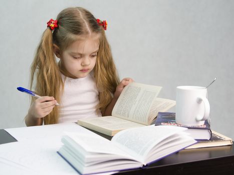 girl sits at a table and flips through the book and writes out the information you need. Next are still books, sheets of paper, a pen, a glass of tea. The image of a student, a pupil, a teacher and literary critic