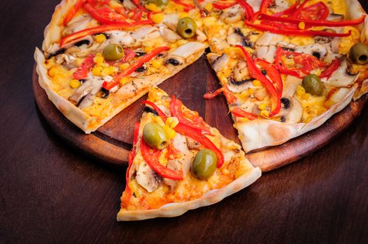 Macro closeup of pizza with mozzarella, mushrooms, olives and red bell pepper