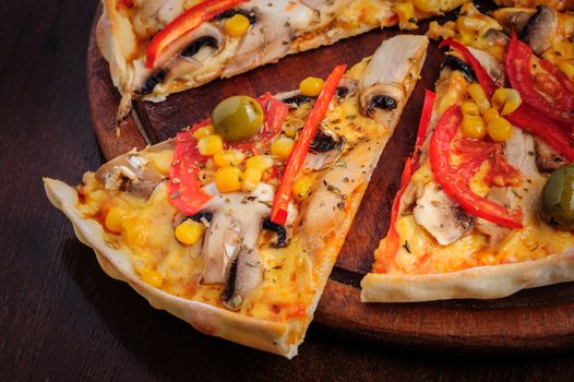 Macro closeup of pizza with mozzarella, mushrooms, olives and red bell pepper