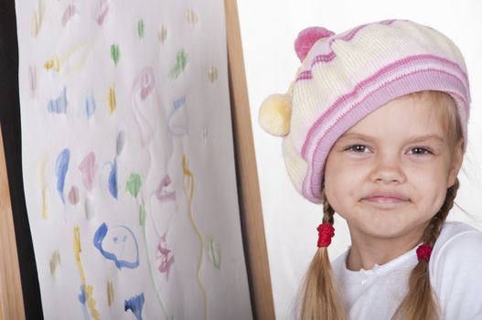 Four-year-old girl playing in artist. girl drew a picture and happily looking at picture.