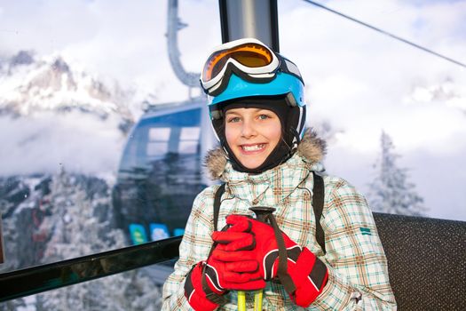 Ski lift, skiing, ski resort - happy skier girl on ski lift.