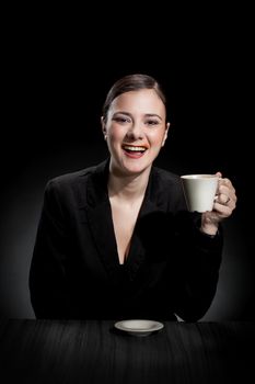 beautiful girl enjoying a cup of coffee on dark background