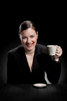 beautiful girl enjoying a cup of coffee on dark background