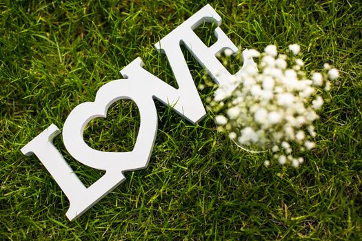 Love is in the air and on the green - Word LOVE lying in lush, well cut grass - Wedding day concept