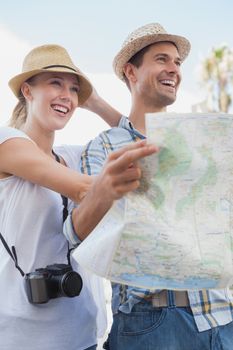 Young tourist couple using the map on a sunny day in the city