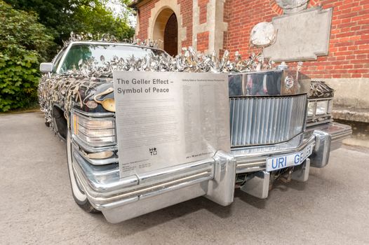 Winnersh, UK - May 18, 2013: The Uri Geller Cadillac art car, decorated with 5000 pieces of cutlery contorted by mind bending; parked at Bearwood College in Winnersh, UK