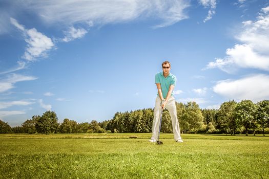 An image of a young male golf player at the green