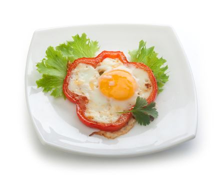 Fried egg with red pepper, fresh lettuce and parsley on the white plate