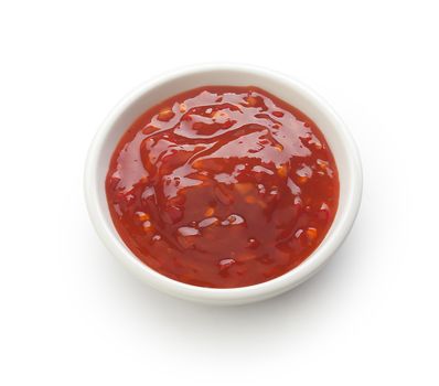 Red chinese spicy sauce in a white gravy boat