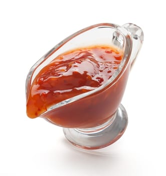 Red chinese spicy sauce in a transparent gravy boat