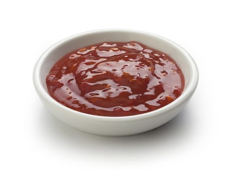 Red chinese spicy sauce in a white gravy boat