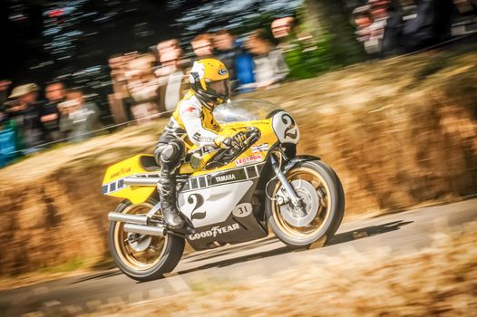 Goodwood, UK - July 1, 2012: Three-time 500cc motorcycle world champion Kenny Roberts on his classic Yamaha YZR500 riding the hill course at the Goodwood Festival of Speed, UK