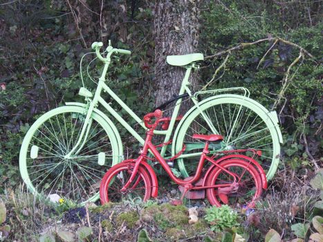 Big and small colorful bicycle stand on a tree