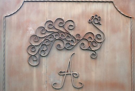 Detail of iron gates with  letter "A" and image of bird                               