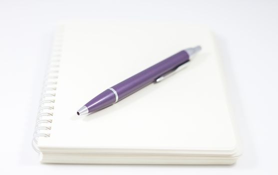 Spiral notebook with pen isolated on white background, stock photo