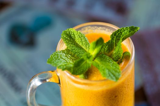 seabuckthorn tea in a glass cup decorated with mint leaves 