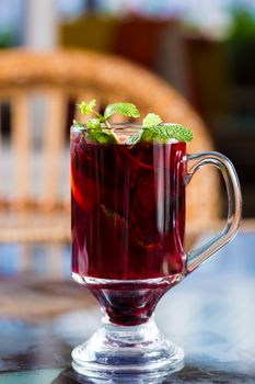 Blackberry tea in a glass cup. Decorated with mint leaves